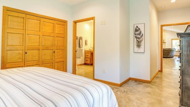 Un dormitorio con cama, armario de madera y puerta que da a un baño.