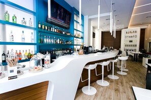Enjoy a drink at the stylish bar with a sleek countertop and comfortable seating.