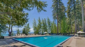 Ein rechteckiger Pool mit einer gefliesten Kante, umgeben von einer Pflasterterrasse.
