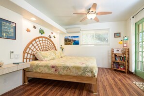 A bedroom with a wooden bed, a ceiling fan, a bookshelf, and a window with blinds. - 🏝 Private Home, Large Lanai -2 Minute Walk to Poipu Beach! 🐠 (Koloa)