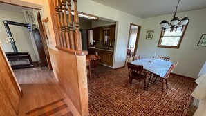 A dining area with a patterned carpet, wooden chairs, and a table with a white tablecloth. - Unplug and enjoy outdoor living at the Lazy Easy (Pet-friendly!) (Bassett)