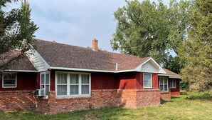 A single-story house with a red brick exterior, a gabled roof, and a small front porch. - Unplug and enjoy outdoor living at the Lazy Easy (Pet-friendly!) (Bassett)