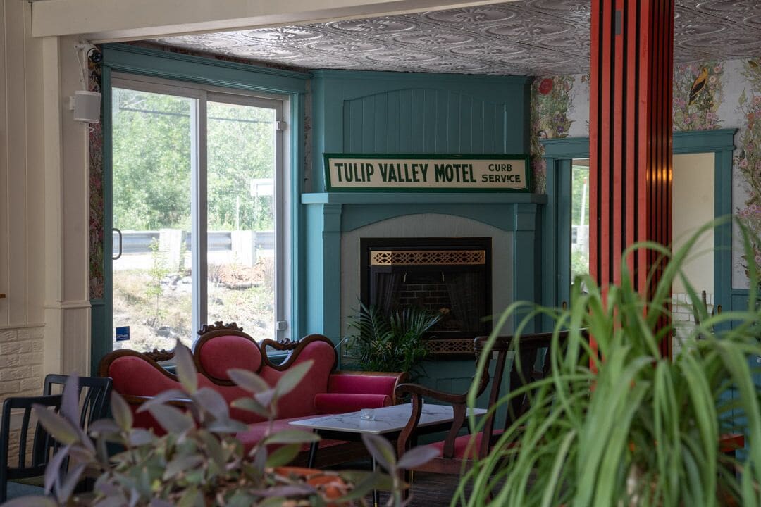 Een gezellig interieur van Tulip Valley Motel, met een open haard, rode zitplaatsen en uitzicht op de omgeving.