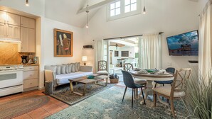 A spacious living area with a kitchen, dining table, and a large window. - Conch Republic Retreat (Key West)
