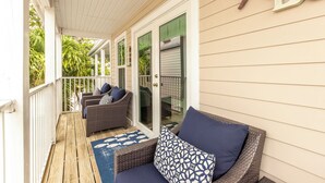 A covered porch with wicker furniture and a starfish decoration. - Duval Square (Key West)