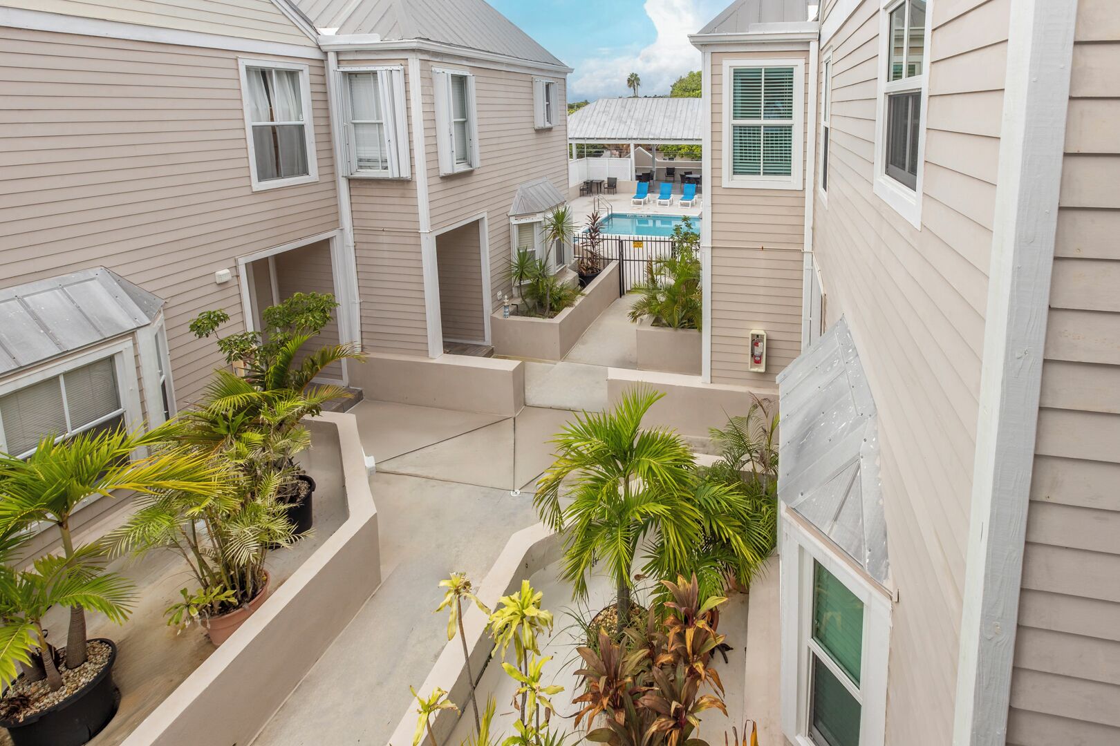 Un immeuble résidentiel doté de nombreux balcons, d’un espace extérieur aménagé pour se détendre et d’une piscine.