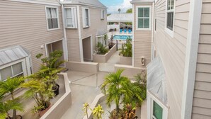 A residential building with multiple balconies, outdoor seating, and a pool area. - Duval Square (Key West)