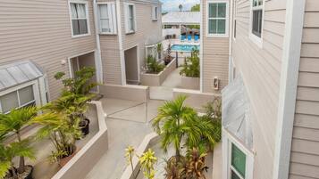 Un immeuble résidentiel doté de nombreux balcons, d’un espace extérieur aménagé pour se détendre et d’une piscine.