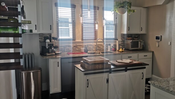 A modern kitchen with white cabinets, a stainless steel refrigerator, a microwave, and a gas stove. - Charming 3 bed/2 bath town home with gorgeous back yard (Springfield)