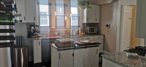 A modern kitchen with white cabinets, a stainless steel refrigerator, a microwave, and a gas stove. - Charming 3 bed/2 bath town home with gorgeous back yard (Springfield)