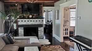 A living room with a fireplace, sofa, and a piano. - Charming 3 bed/2 bath town home with gorgeous back yard (Springfield)