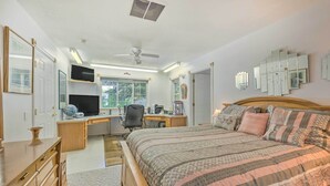 Une chambre à coucher comprenant un lit, un bureau, une chaise et un téléviseur.