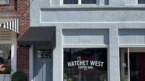 Un café appelé Hatchet West, doté d’une grande vitrine et d’une façade en briques.