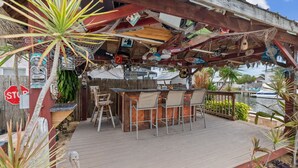 A wooden deck with a bar area, chairs, and a stop sign.