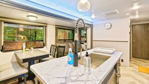 Una cocina moderna con encimera de mármol, un lavabo y una lámpara colgante.