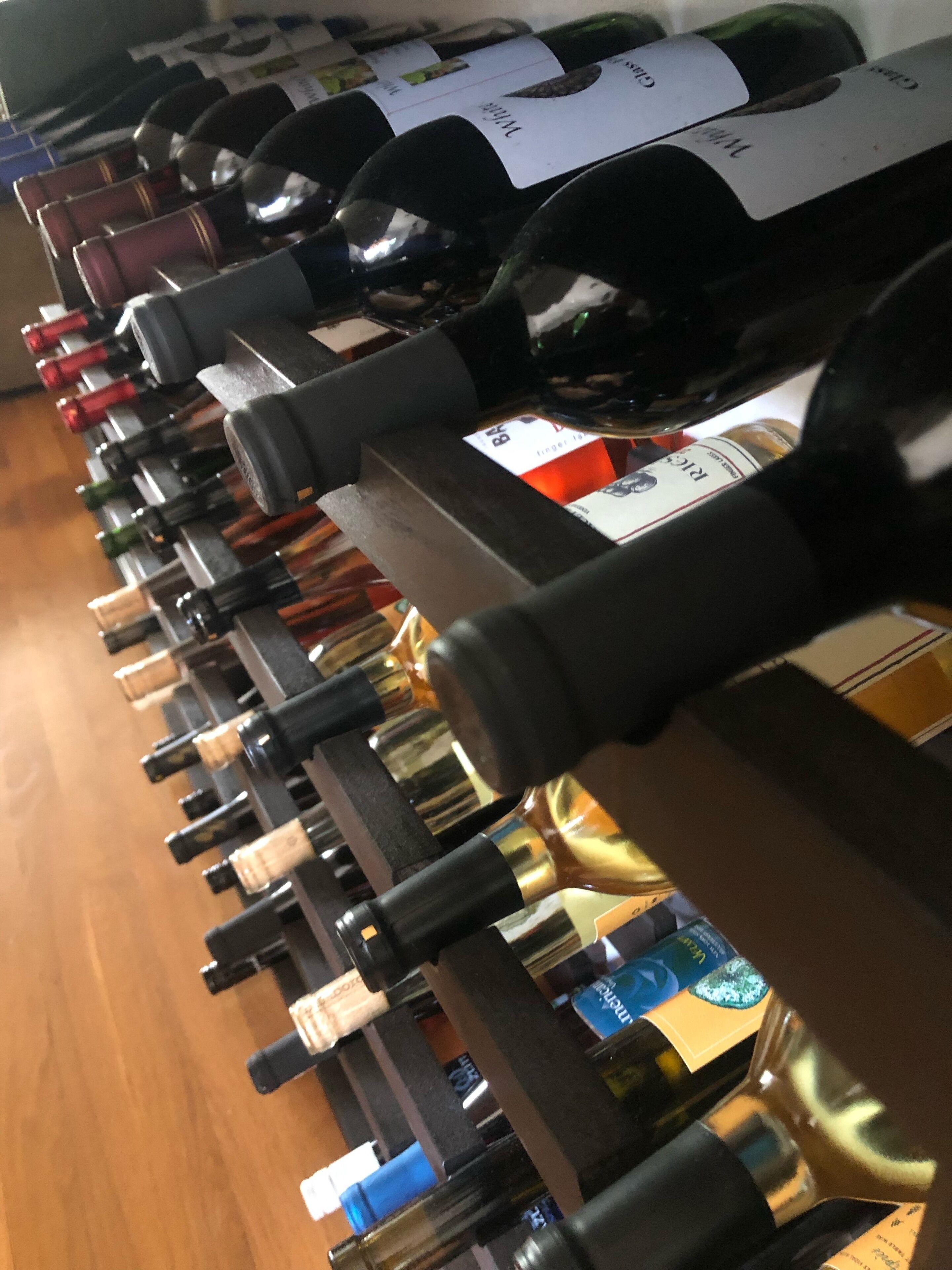 A row of wine bottles on a wooden shelf.
