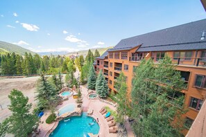 A resort with a swimming pool, outdoor seating, and a view of the mountains. - Springs 8913 (Keystone)