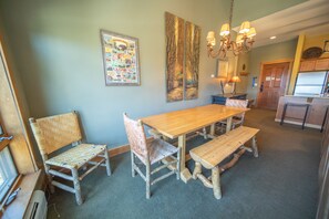 A dining area with a wooden table and chairs, a chandelier, and a framed picture on the wall. - Springs 8913 (Keystone)
