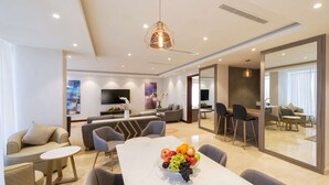 A modern living room with a dining area, a TV, and a large mirror.