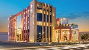 A modern hotel with a prominent entrance, large windows, and a well-lit facade.