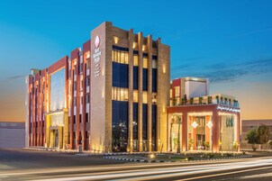 A modern hotel with a prominent entrance, large windows, and a well-lit facade.