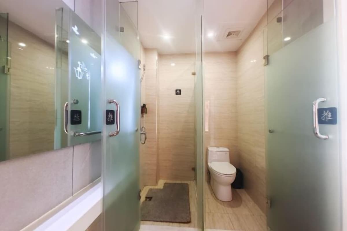 Un baño moderno con cabina de ducha de vidrio, inodoro y lavamanos.