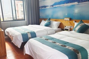 Een hotelkamer met twee bedden, een houten hoofdeinde, een raam met uitzicht over de stad en een schilderij aan de muur.