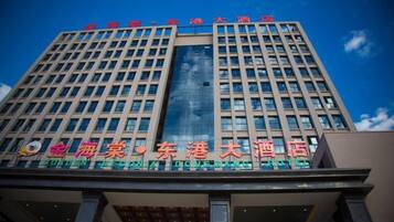 A multi-story hotel building with a prominent sign indicating it is the Golden Beach Donggang.