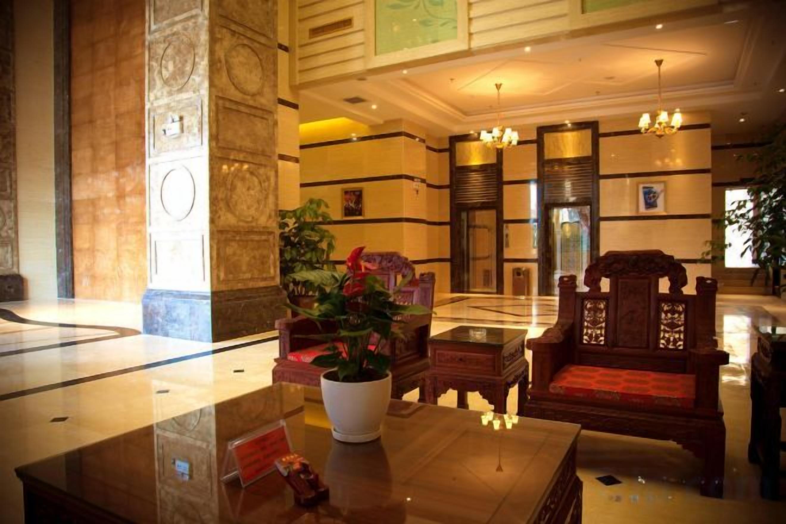 A lobby with a reception desk, seating area, and a large plant.