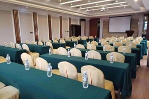 A conference room with rows of tables, chairs, and water bottles. - Golden Begonia Donggang Hotel Lincang (Lincang)