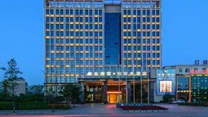 A multi-story hotel with a prominent entrance and signage indicating it is a hotel. - Golden Begonia Donggang Hotel Lincang (Lincang)