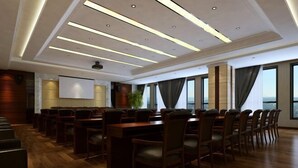 A conference room with a long table, chairs, a projector, and a screen. - Golden Begonia Donggang Hotel Lincang (Lincang)