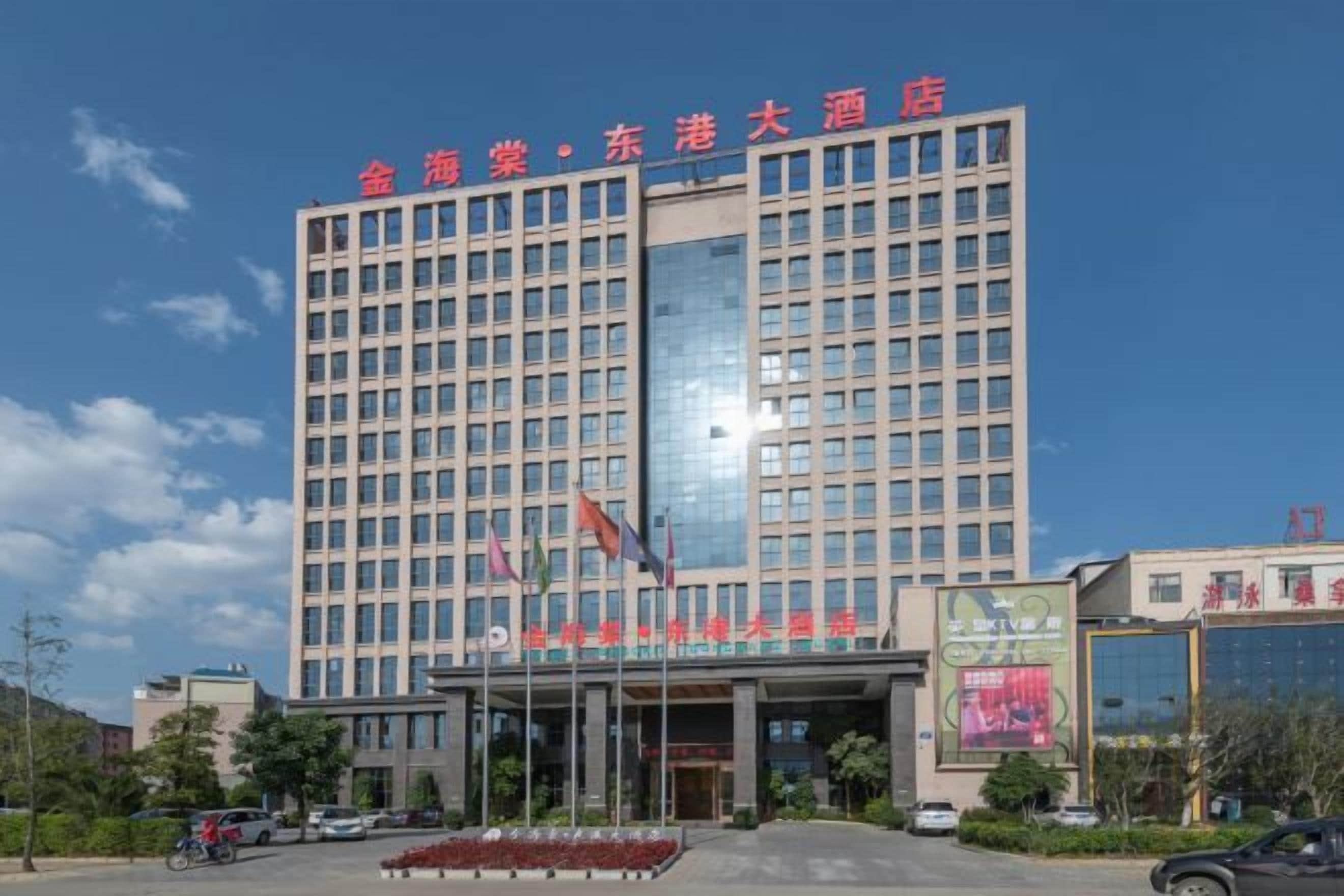 A multi-story hotel building with a prominent entrance and a large glass facade.