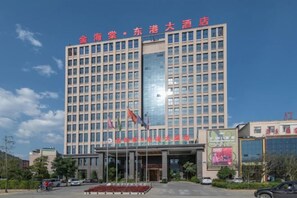 A multi-story hotel building with a prominent entrance and a large glass facade. - Golden Begonia Donggang Hotel Lincang (Lincang)