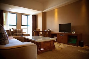 Una sala de estar con sofá, mesa de centro, televisor y chimenea.