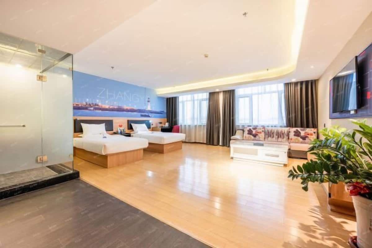 Een moderne hotelkamer met een groot bed, een bank, een salontafel en een televisie.