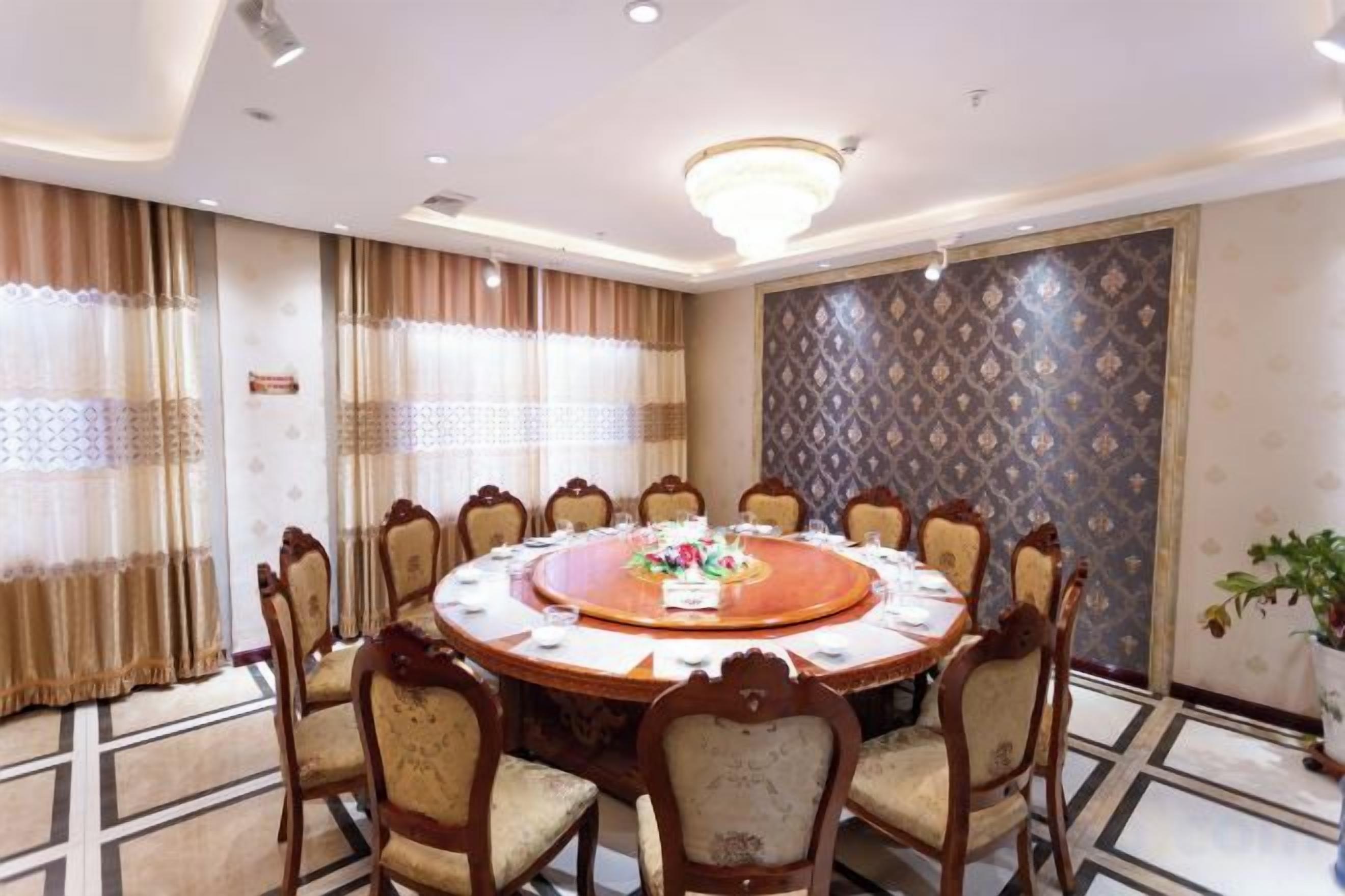 A conference room with a round table, chairs, and a chandelier.