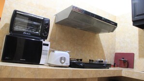 Een keuken met een magnetron, broodrooster en een gasfornuis.