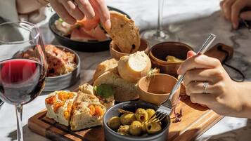 A dining table with various food items and glasses of wine.