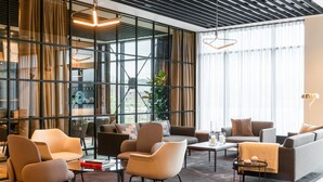 A modern hotel lobby with a mix of seating areas, large windows, and a contemporary design. - AC Hotel by Marriott Inverness (Inverness)