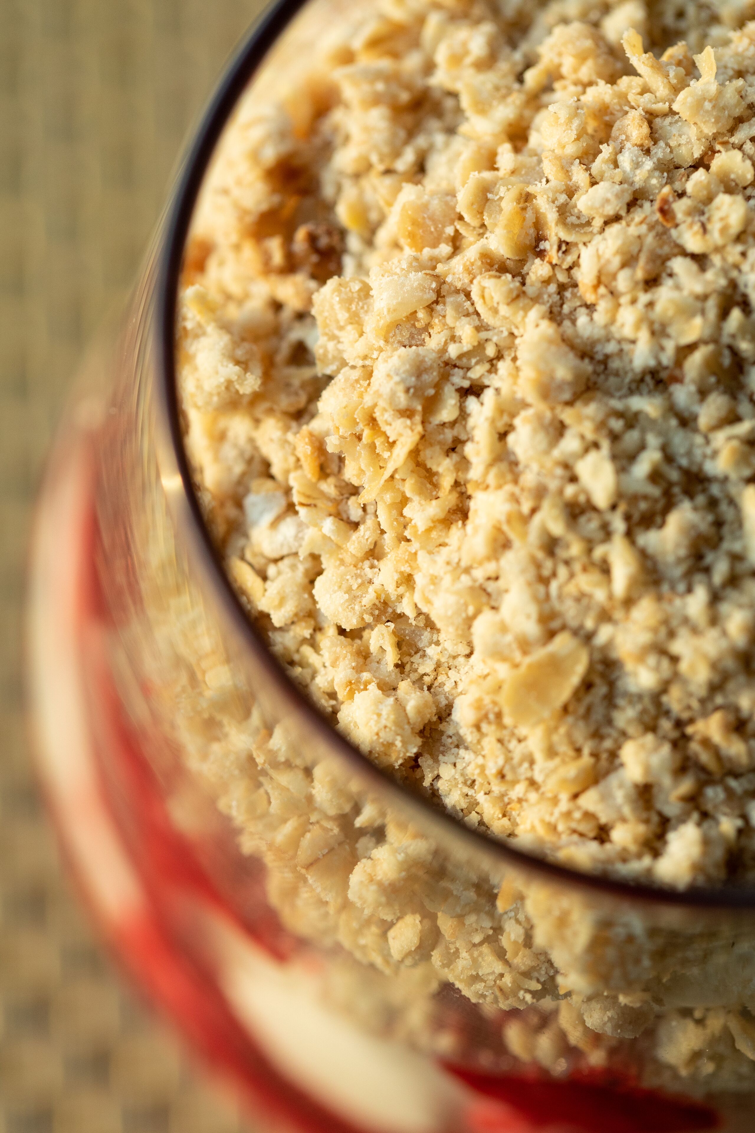 A close-up of a glass bowl filled with a crumbly, textured food item.