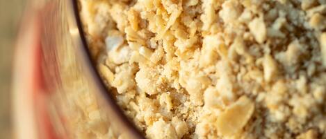 A close-up of a glass bowl filled with a crumbly, textured food item.