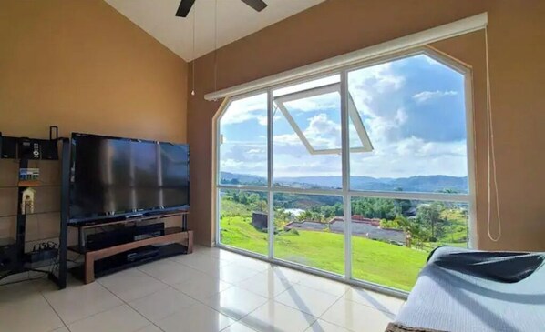 Enjoy a panoramic view of the surrounding hills from the large window in this stylish room.