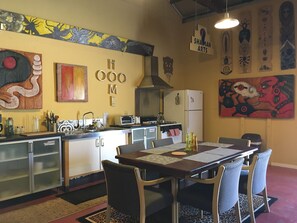 Une cuisine moderne avec un coin repas, comprenant une cuisinière, un réfrigérateur et divers appareils de cuisine.