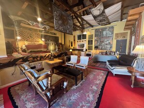 Une pièce comprenant un lit, un bureau, une chaise et un canapé. Il y a une fenêtre et une porte.