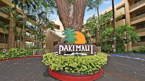 A sign for Pakimaui with a large tree and palm trees in the background. - Perfect Romantic Getaway - Right on the Ocean! (Lahaina)