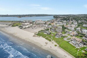 Un quartier résidentiel situé sur la côte, avec des propriétés donnant sur la plage, un grand hôtel et un port de plaisance.