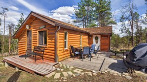 A log cabin with a deck, outdoor seating, and a grill. - Charming Cabin on Dream Property (Pine)