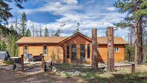 A log cabin with a porch, a grill, and a dining area. - Charming Cabin on Dream Property (Pine)