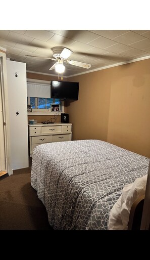 Cozy retreat with a single bed, flat-screen TV, and dresser.